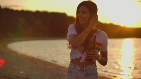 Das-Mädchen-Lacht-Und-Fährt-Sich-Bei-Sonnenuntergang-Am-Strand-Durchs-Haar.-Das-Ist-Ein-Perfekter-Sommerabend-Mit-Bier-Und-Freunden.